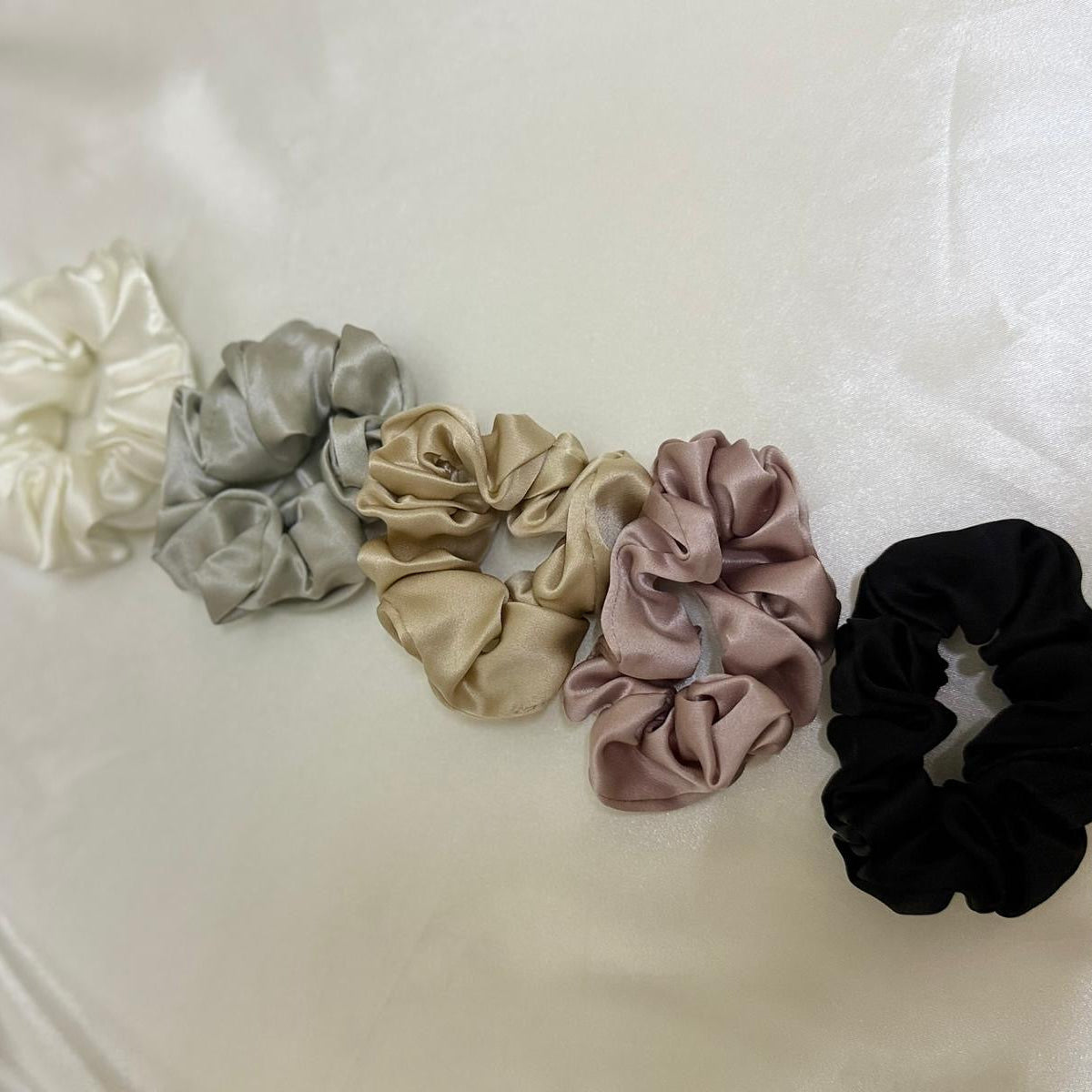 Set of five colorful scrunchies on a white surface